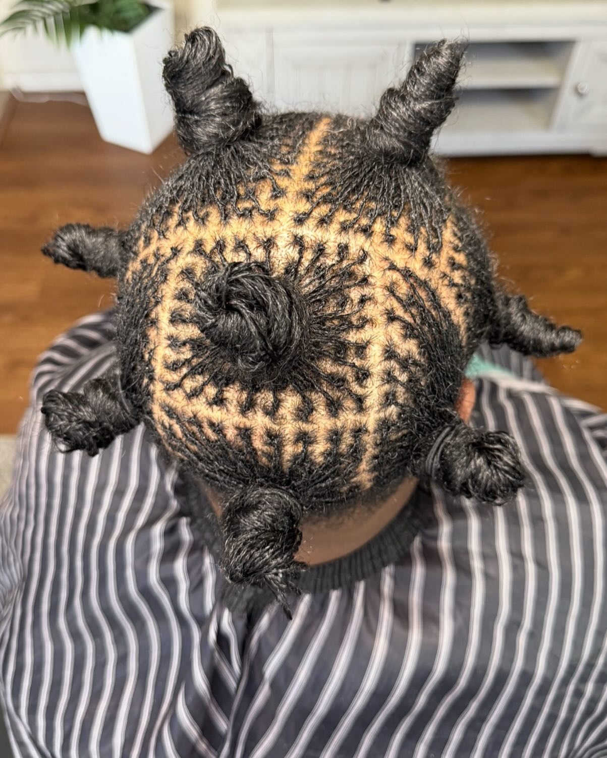 Intricately braided hair styled into geometric patterns with bun-like twists.