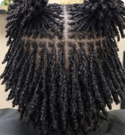 Close-up of textured twists hairstyle with a unique cross pattern shaved design.